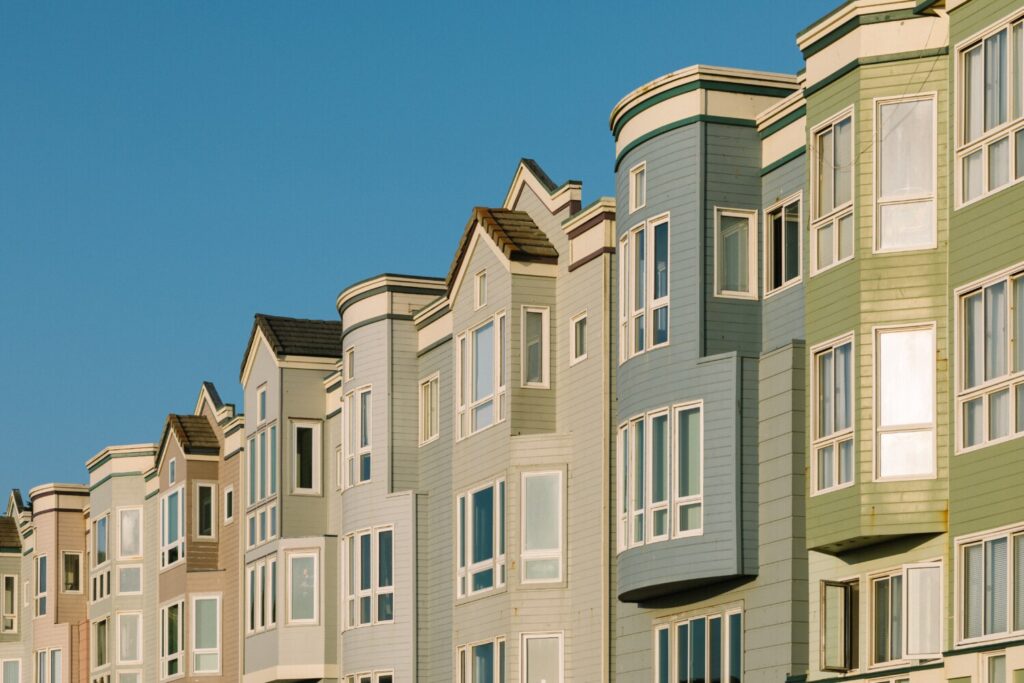 A beautiful shot of different color apartments near each other with a clear sky in the background